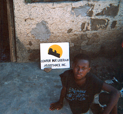 A picture of a child with a sign that says Center for Liberian Assistance